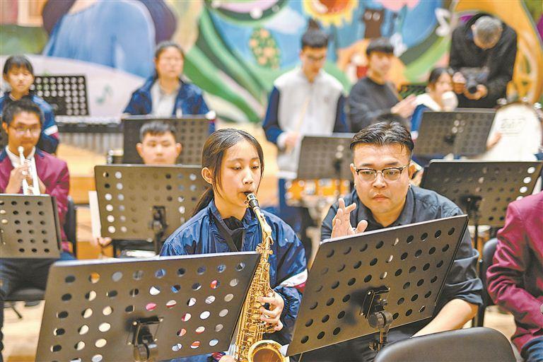 聋生演奏者演奏时，老师在旁边用手势为其示意节拍。图为排练现场。（林铭鸿 摄）